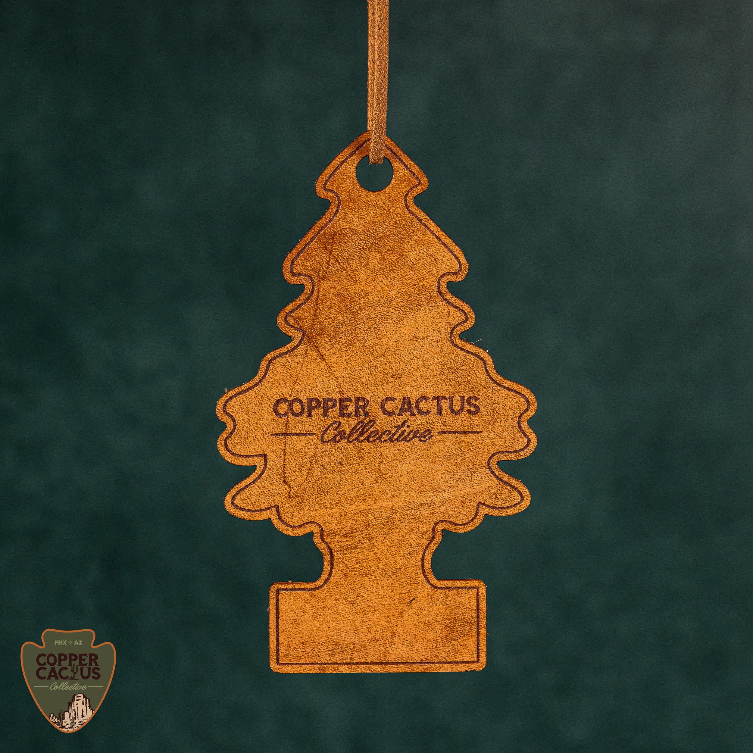 Wooden tree-shaped ornament with 'Copper Cactus Collective' branding on a dark green background.