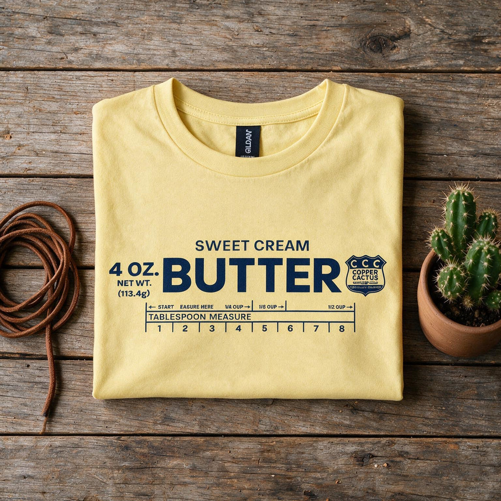 Woman wearing yellow Sweet Cream Butter T-shirt and cowboy hat by a barn