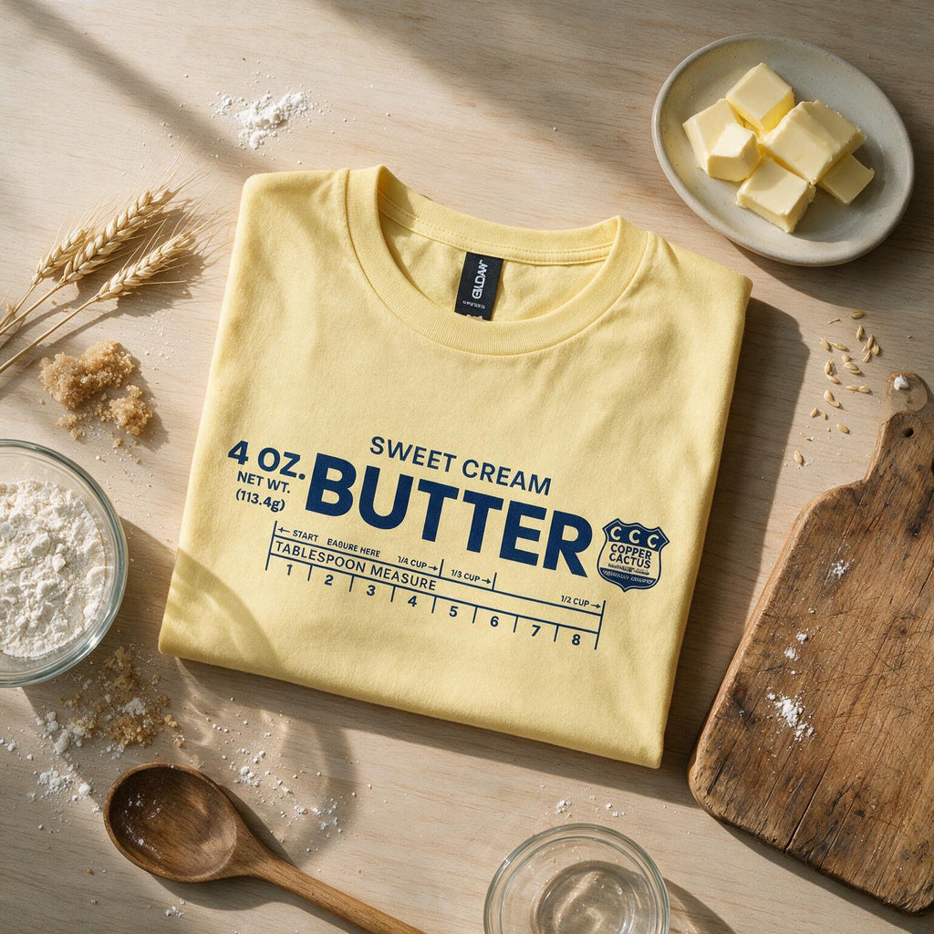 Folded yellow Sweet Cream Butter T-shirt styled with baking ingredients