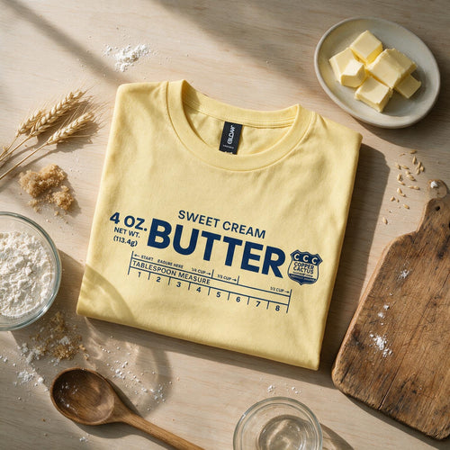 Folded yellow Sweet Cream Butter T-shirt styled with baking ingredients